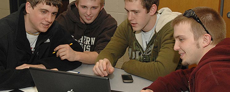 Students discussing around computer
